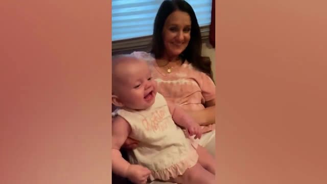 baby laughing with dog barking