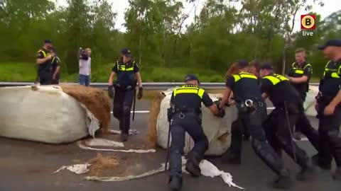 Farmers Convoy: Dutch police can't push bale's of hay off road.