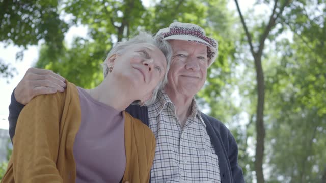 Cute old couple, hugging in a park