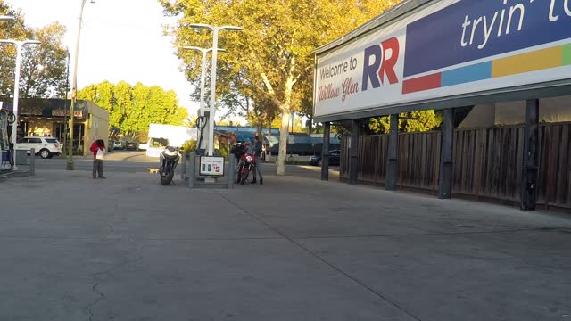 Motorcyclists discuss a matter with a drifter standing near by