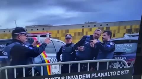 Brazilian police taking selfies while people are storming the capitol building