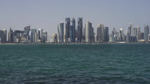 Ocean water ripples in front of city skyscrapers