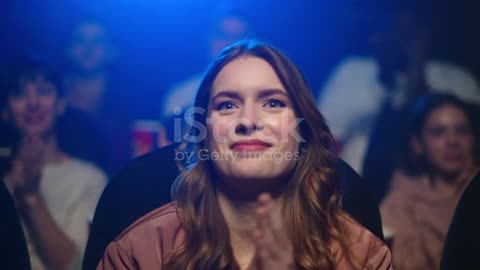 "Captivated Audience: Joyful Reactions at Movie Premiere"