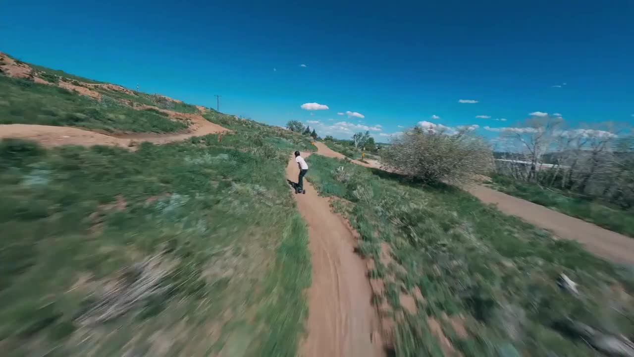 Man Rides Longboard Through Winding Dirt Track