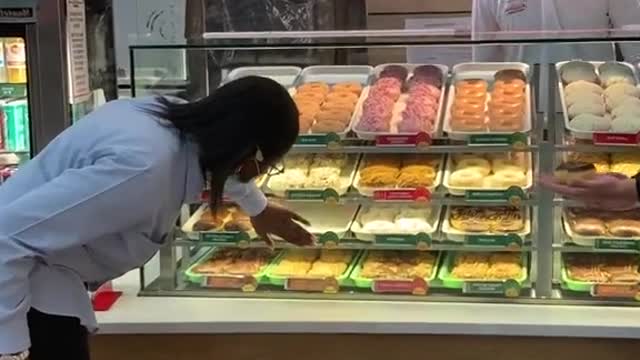 The boy took dessert through the glass and the surrounding people stared at it