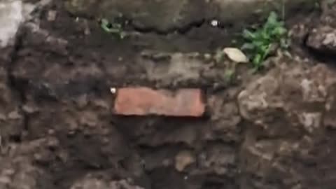 A lone red brick amongst the foundations