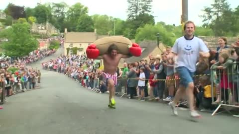 Runners take part in annual uphill race carrying large sacks of wool