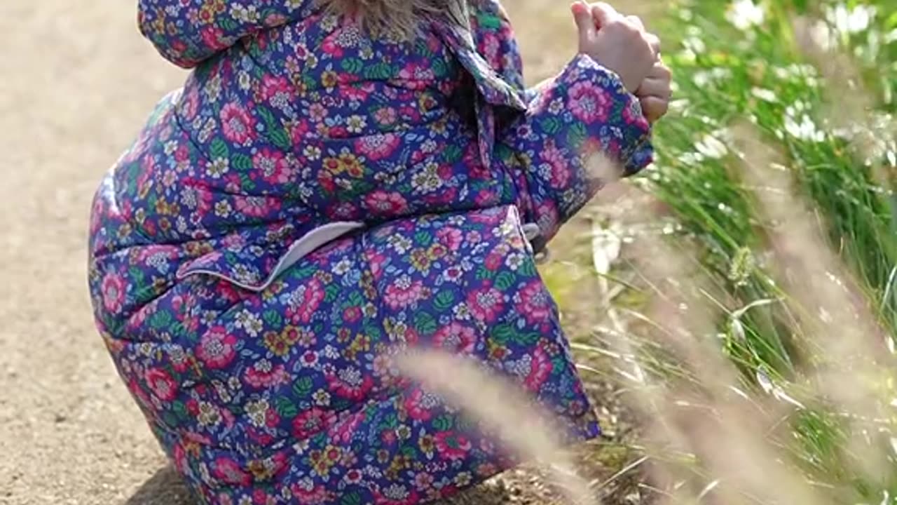 cute baby holding flower plant in mouth