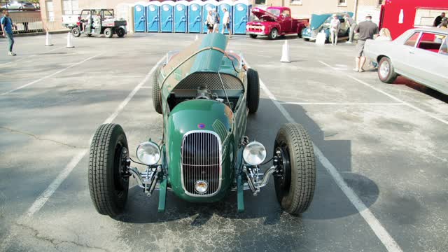 A Green Vintage Automobile With An Open Hood Parked