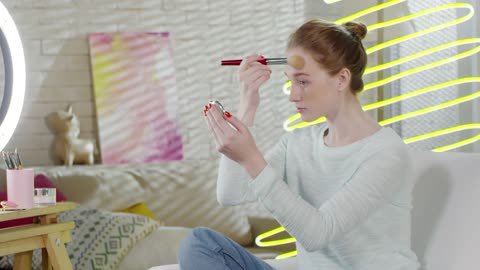 A woman using a brush to applying her face makeup