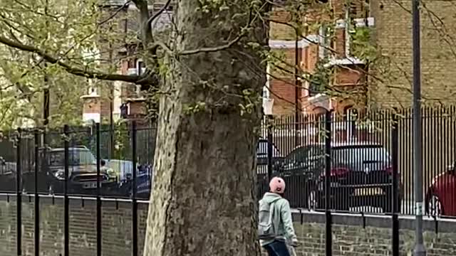 Guy Speeds Across the Park on his Hoverboard While Dragging his Suitcase Along