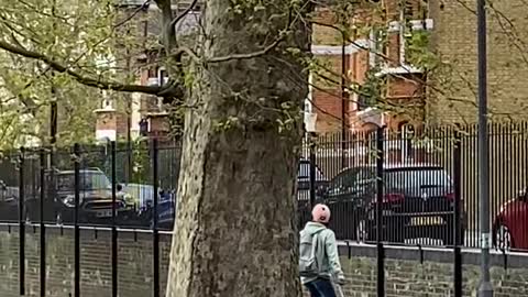 Guy Speeds Across the Park on his Hoverboard While Dragging his Suitcase Along