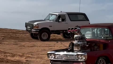 Old-school truck speeding through the sand