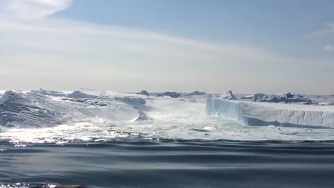 Ilulissat Icefjord - Large iceberg breaking over