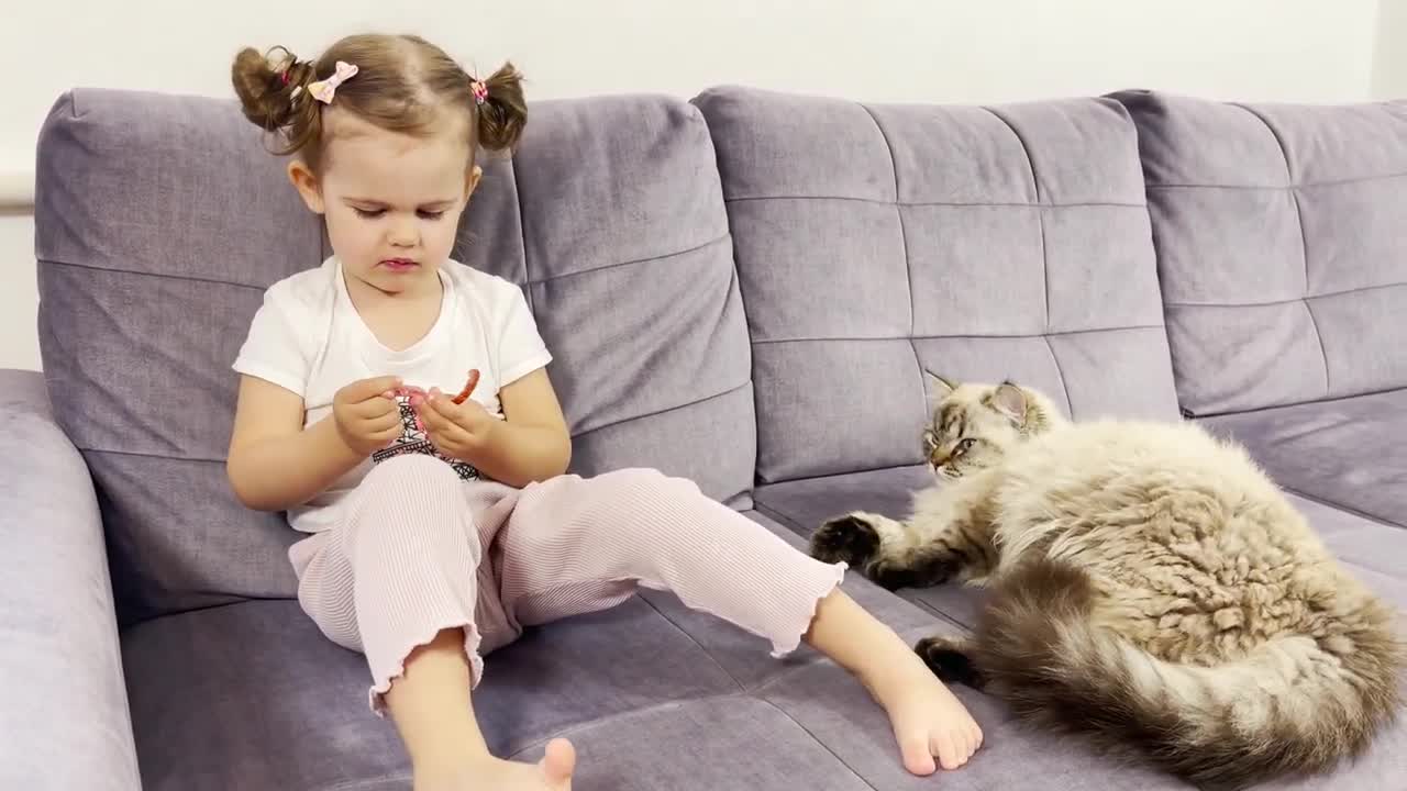 What Does a Baby Girl do When a Cat Wants to Take Sausage From Her