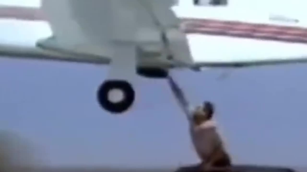MECHANIC FIXING A BROKEN LANDING GEAR FROM A MOVING VEHICLE IN 1985