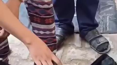 A young Palestinian girl bids farewell to her sister who was killed in Israeli airstrikes