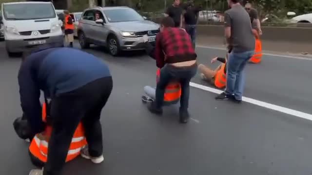 Fed-up French motorists haul off climate activists blocking the A6 near the Paris-Orly Airport.