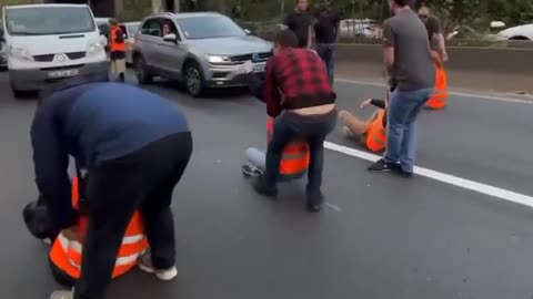 Fed-up French motorists haul off climate activists blocking the A6 near the Paris-Orly Airport.