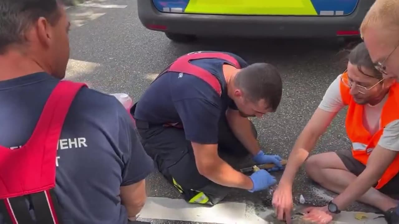 Eco activist screams in pain as workers try to unstick his hand after he glued himself to the road