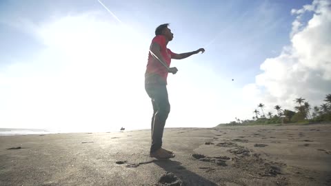 Man Pulling on a Kite String on a Beach