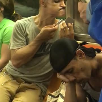 Man in grey shirt shaving chin