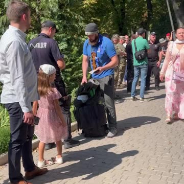 Ukrianian police hand conscription notices to men attending UOC procession