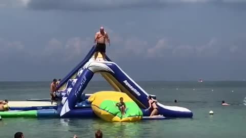 Guy jumps and tosses girl into water