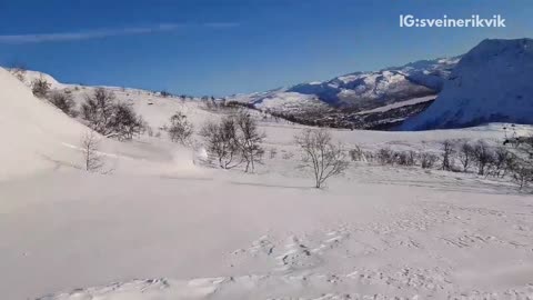 Man on skis flips forward on snowy hill