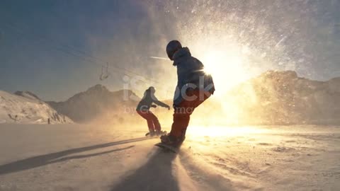 PEED RAMP Zwei Snowboarder fahren in Richtung der untergehenden Sonne