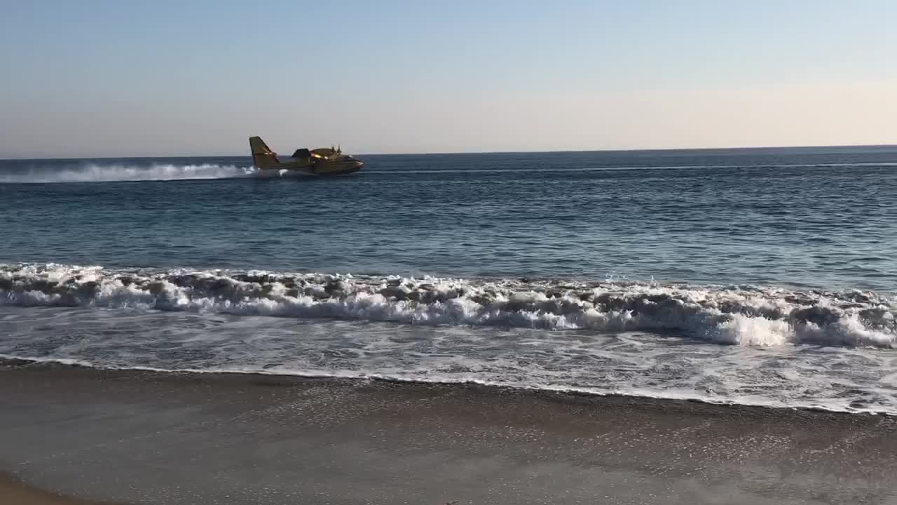 Aircraft Retrieves Ocean Water for Fire Fighting Efforts