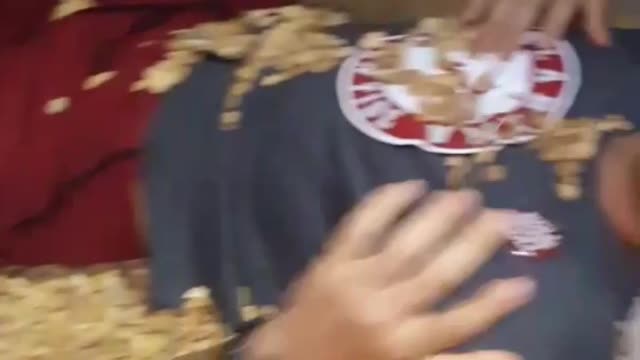Guy grey shirt on ground getting rocks thrown at him
