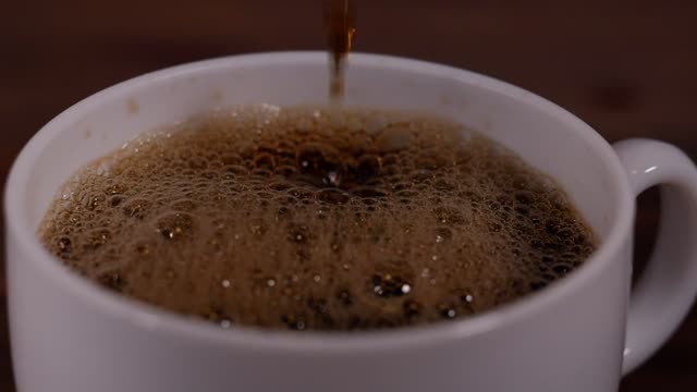 Filling a white cup of coffee