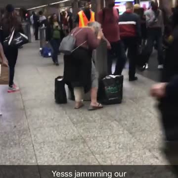 Woman in pink dances to music in subway