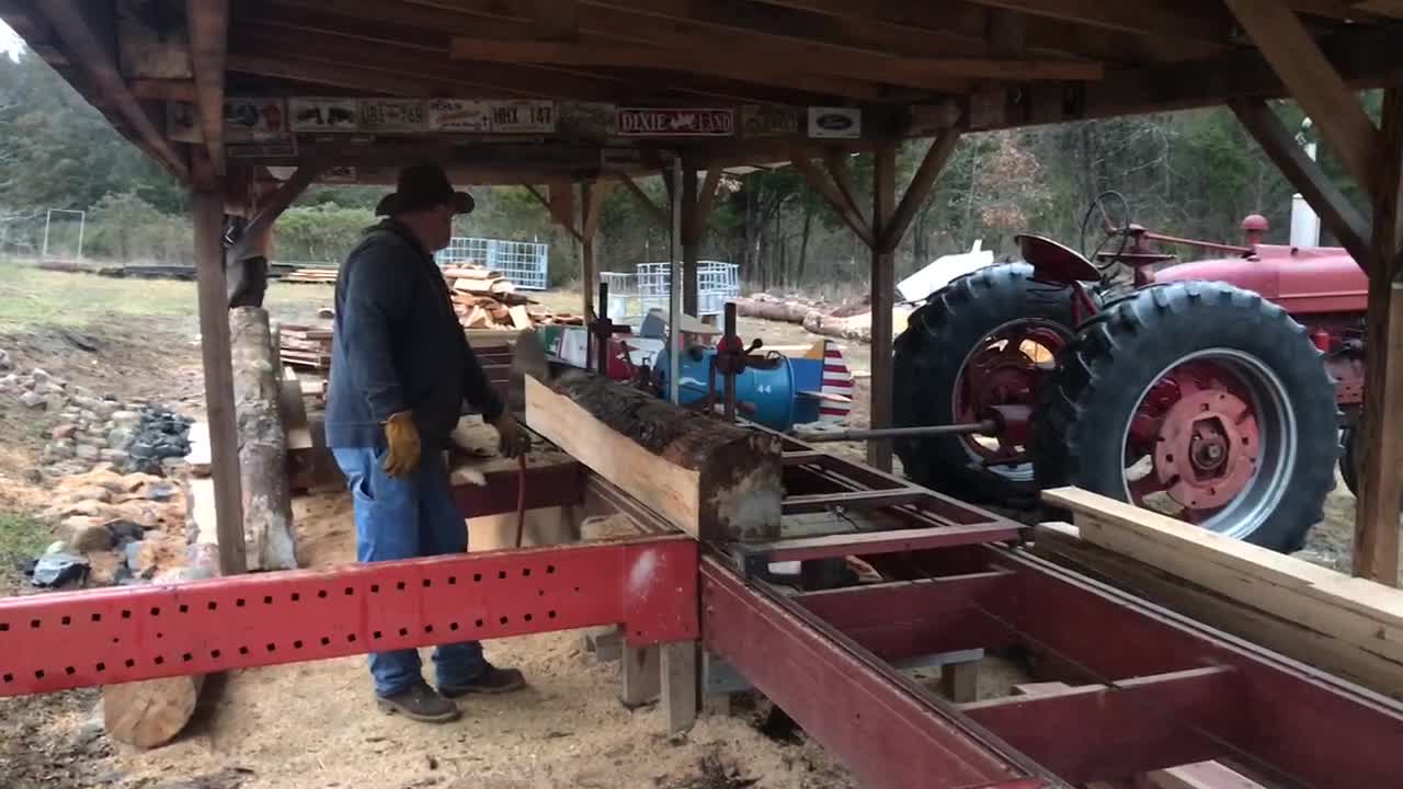 Sawing logs for log cabin project