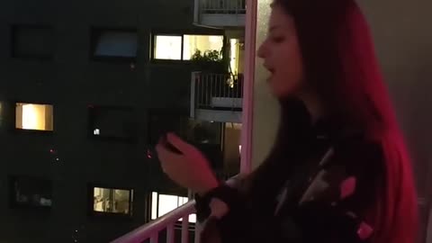 Talented young woman sings 'Hallelujah' from the balcony in Paris