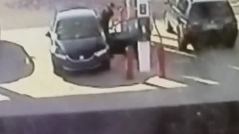 A man in black car breaks door at gas station