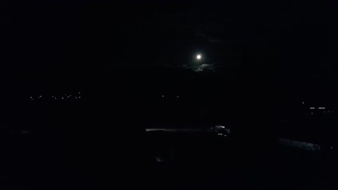 The Beautiful full moon and a car passing on the road