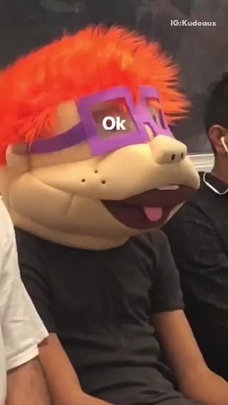 Man wearing chuckie hat on subway train