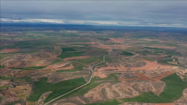 aerial view desert landscape with a road and green fields high altitude spain teruel province