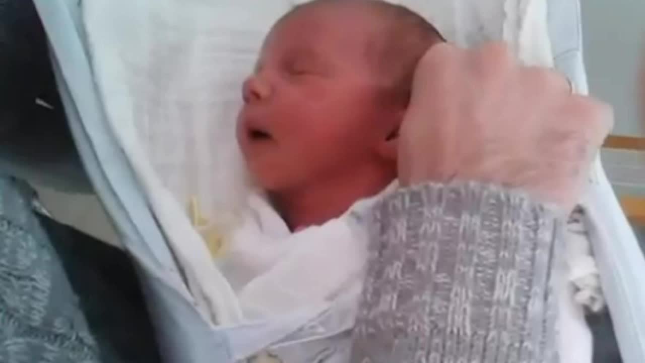 Newborn baby falls asleep in daddy's hands at the hospital