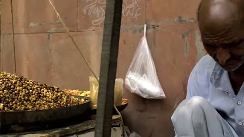 Elderly Man Fills and Weighs a Bag of Chickpeas