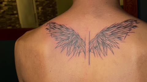 Upper back wing tattoo