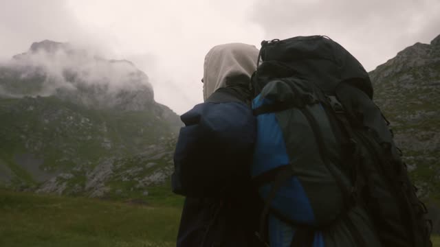 A Hiker Looking at the Mountains
