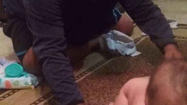 Dad Hilariously Struggles with Baby During Diaper Change