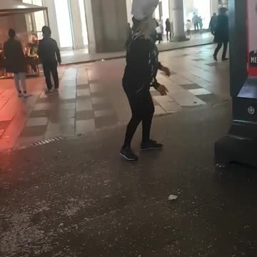Woman balances plastic bag on her head and shares a cigarette