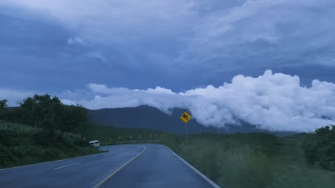 Going down Curved highway through a mountain range