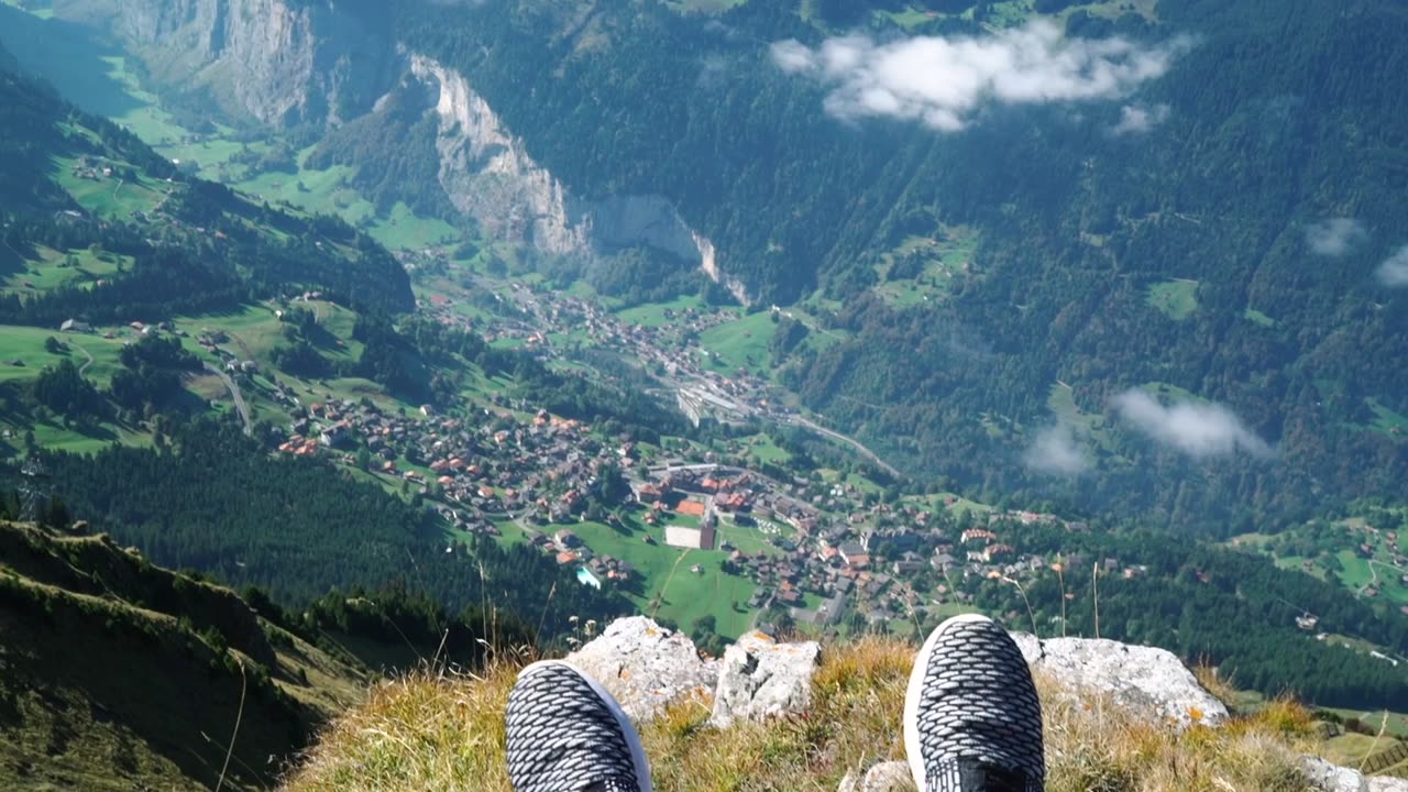 Person On A Cliff Overlooking The Mountains