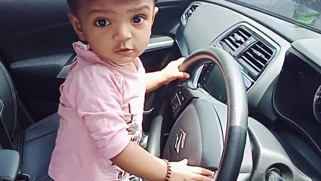 A little girl driving her father's car...