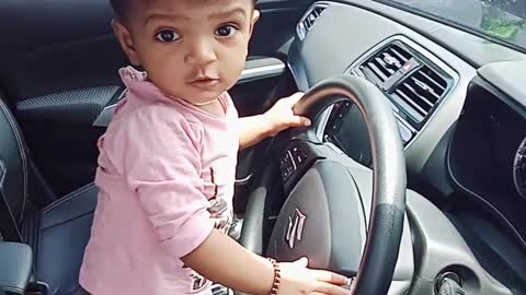 A little girl driving her father's car...